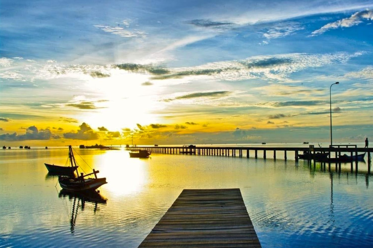 A beautiful sunset at Ham Ninh fishing village with golden hues reflecting on the water
